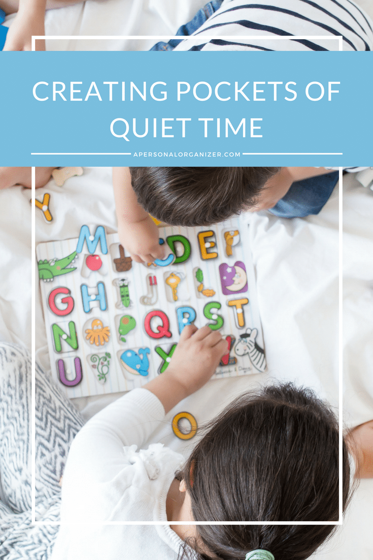 Children playing with an alphabet puzzle on a white surface. A blue overlay at the top contains white text that says, "CREATING POCKETS OF QUIET TIME," with the website "APERSONALORGANIZER.COM" below it.