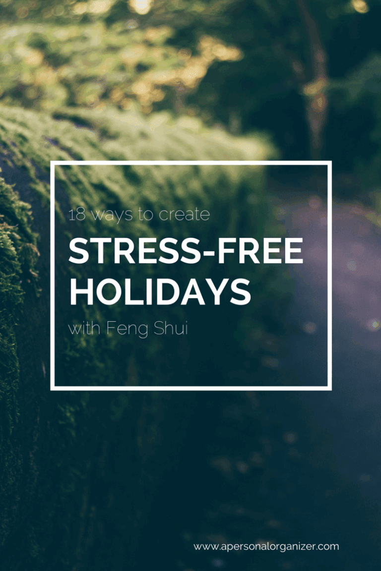 A blurred forest path with lush greenery and moss-covered stones. White text overlay reads: "13 ways to create STRESS-FREE HOLIDAYS with Feng Shui." Discover tips for truly stress free holidays at apersonalorganizer.com.