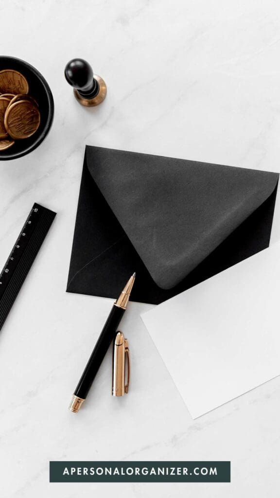 Black envelope, white paper with open pen.