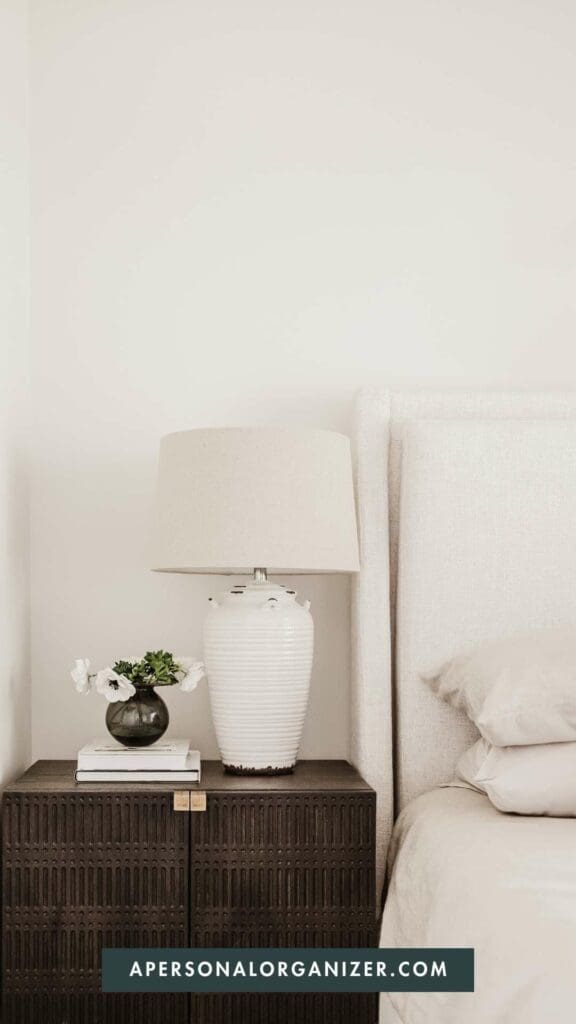 Nightstand with white lamp next to bed | apersonalorganizer.com